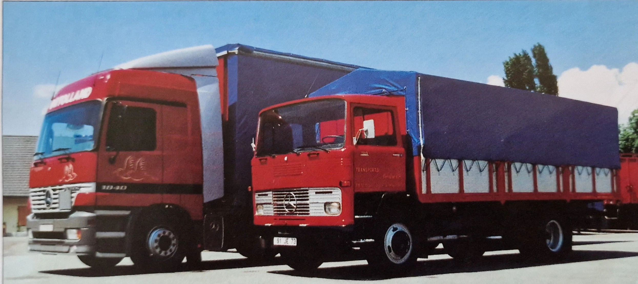 Deux générations de camions ORTOLLAND, aux couleurs rouges et bleues de l'entreprise